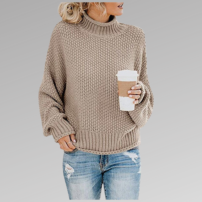 Woman in a beige turtleneck knit sweater holding a coffee cup, wearing ripped jeans. Fall fashion trend, casual look, cozy style.