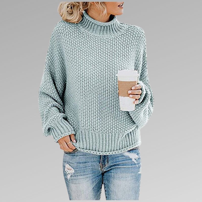 Woman in a light blue knit sweater holding a coffee cup, wearing ripped jeans. Fashion trend, fall fashion, casual style, cozy look.