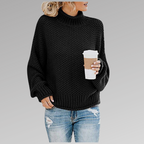 Woman in a black knit sweater with a coffee cup, wearing ripped jeans. Fall fashion trend, casual look, cozy style.