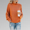 Woman in an orange knit sweater holding a coffee cup, wearing ripped jeans. Fall fashion, casual style, cozy look.