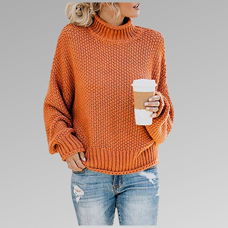 Woman in an orange knit sweater holding a coffee cup, wearing ripped jeans. Fall fashion, casual style, cozy look.